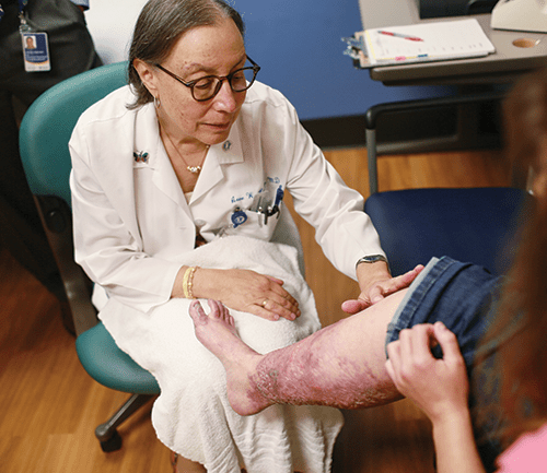 Anne Lucky, MD, examines a patient at the Cincinnati Children's epidermolysis bullosa (EB) clinic. EB is a rare genetic connective tissue disorder that affects one in 20,000 births in the U.S. The condition is marked by extremely fragile skin that breaks easily from minor friction or trauma.
